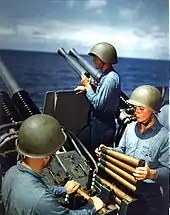 The US Navy Mk II talker helmet, worn by the sailor in the rear-center of the image; The two sailors in the foreground wear the M1 helmet