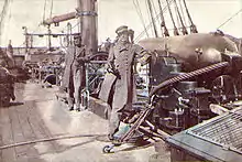 Captain Raphael Semmes, Alabama's commanding officer, standing aft of the mainsail by his ship's aft 8-inch smooth bore gun during her visit to Cape Town in August 1863. His executive officer, First Lieutenant John M. Kell, is in the background, standing by the ship's wheel.