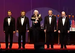 Five men standing on a stage.