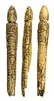 Elongated figurine with hooded, decorated, overall and traces of paint.