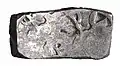 Short "bent-bar" punch-marked coin minted under Achaemenid administration, of the type found in the Shaikhan Dehri hoard.