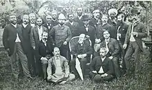 A portrait of twenty men (five seated in front) on a lawn