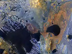 There is a crater nearly 50 kilometers in diameter inside the 167-kilometer Becquerel crater. This image shows layered blocks tilted at high angles, diverse color and textures and dark dunes. Some of the bedrock may have originated at great depths, uplifted first by Becquerel and later by the unnamed 50-kilometer crater. Very complex geology here.
