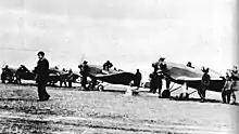 Polish Air Force Academy airfield with four planes and a number of men around them